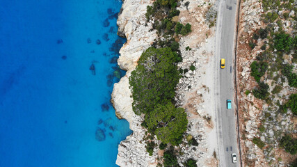 Aerial. Cars driving by the highway near the mediterranean sea. Top view from drone.