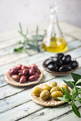 Obraz na płótnie Canvas Variety of black and green olives and olive oil in bowls on white background close up