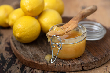 Thick honey in a glass jar and lemons