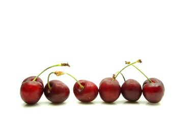 Línea de cerezas sobre fondo blanco. Fruta fresca y saludable.