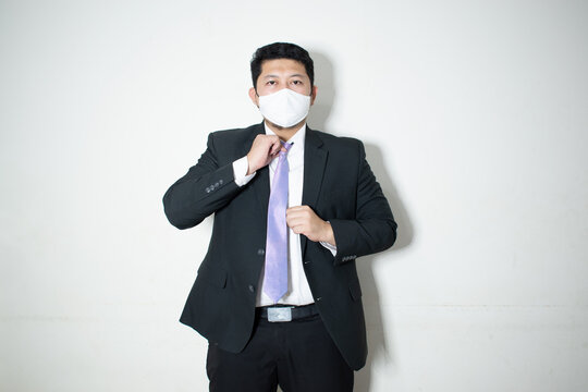 Young asian business man in face mask using laptop computer isolated on white background, quarantine and epidemic covid-19, businessman work from home for health, social distancing, new normal.