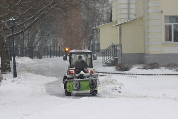 snowplow cleans the road near the house