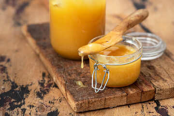 Thick honey in a glass jar on a wooden background