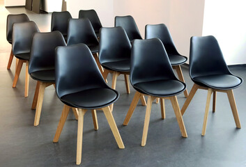 Minimalist Scandinavian design of conference room. Rows of black chairs in meeting room. Seats for...