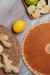 Lime and ginger fruit leather with fresh fruits on the wooden table. Round fruit leather. Healthy food. Apples, bananas, lime, ginger top view.