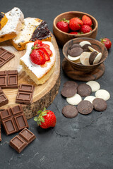 front view cake slices with chocolate bars and cookies on grey background fruit sweet pie