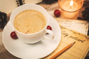 Cup of hot chocolate and cozy cards with decorations and candles, composition of the season of the year