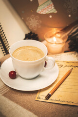 Cup of hot chocolate and cozy cards with decorations and candles, composition of the season of the year, vertical photo