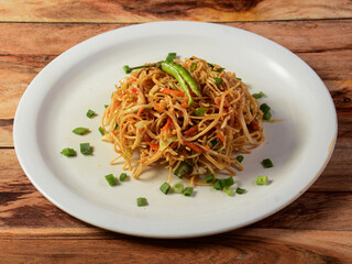 Chinese Bhel, is a spicy indo chinese recipe, served over a rustic wooden background, selective focus