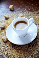 Cup of coffee and brown sugar on wooden background. Close up. 