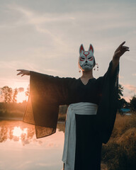 The girl in the mask of the Japanese wolf Okami walks through the beautiful fairytale near the...