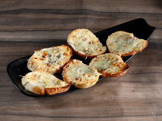 Garlic bread, served over a rustic wooden background, selective focus