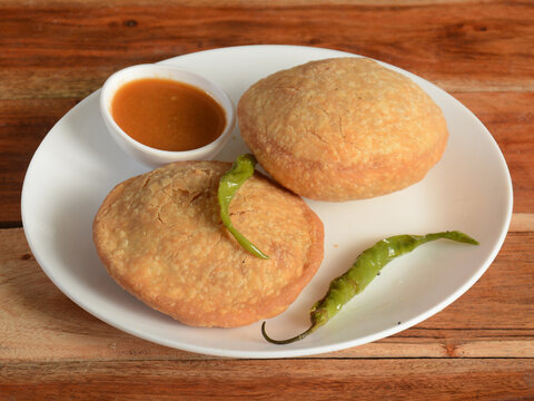 Kachori a famous midday snack in india, served over a rustic wooden background, selective focus