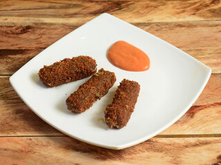 Mozzarella cheese sticks with Barbeque sauce served over a rustic wooden background, selective focus