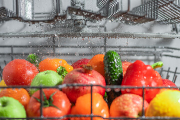 Fresh and beautiful vegetables and fruits are washed in the dishwasher, inside view, drops and...