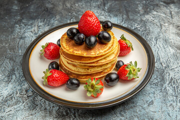 front view delicious pancakes with fruits and berries on dark floor fruit cake dessert