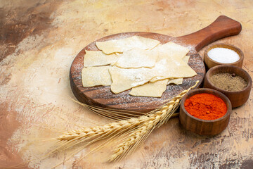 front view raw dough slices with flour and seasonings on wooden desk dish pasta cuisine