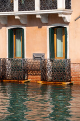 Venice, Italy. Close up of a waterfront building with wooden portal or door partly submerged by the water. Water at very high level submerging steps and doorways and almost touching the windows.