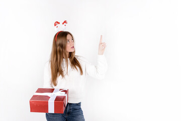 Happy beautiful woman with christmas gift box isolated on white background wearing santa hat showing on empty space