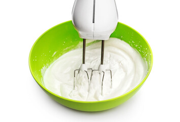 Electric mixer and green bowl with whipped eggs on white.