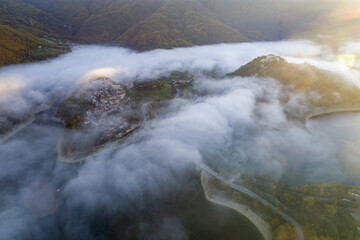 Aerial view of Castel di Tora. Fly through the clouds on Lake Turano.