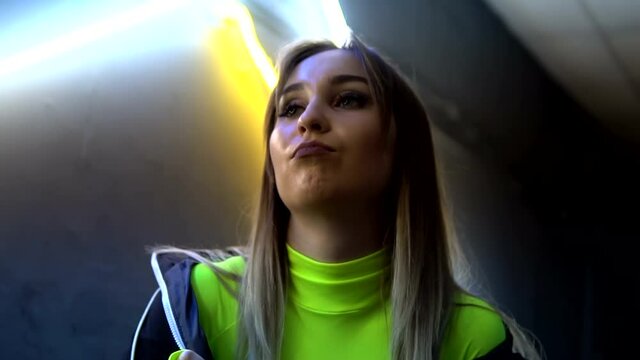 Fashionable girl dancing on the background of the neon lapms