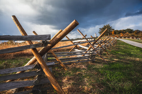 Virginia worm fence or split rail fence constructed of wood located at Oak Ridge on the field where the Battle of Gettysburg took place during the Civil War, with the Eternal Light Peace Monument in t