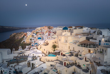Oia town on Thira. Santorini island with colorful volcanic cliffs and deep blue sea aerial view