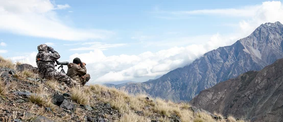 Foto op Plexiglas Two men in camouflage conduct surveillance high in the mountains. © okyela