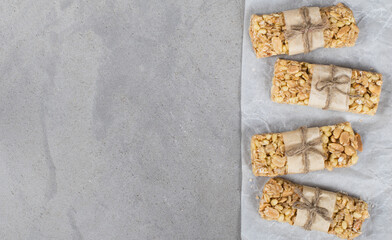 Fitness bars peanuts hazelnuts oatmeal on a light gray background top view copy space