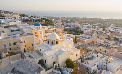 Oia town on Thira. Santorini island with colorful volcanic cliffs and deep blue sea aerial view