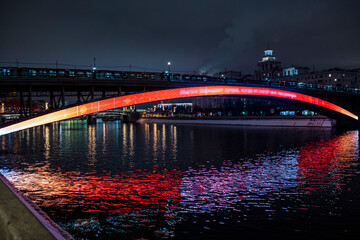 evening winter cityscape with river bridge and illuminated buildings