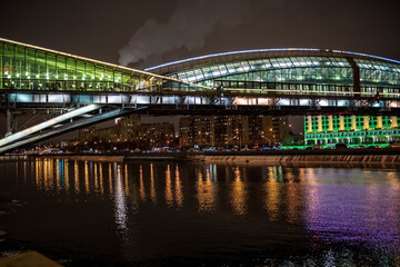 evening winter cityscape with river bridge and illuminated buildings