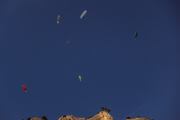 Fototapeta na wymiar colorful paraglider and a glider on blue sky in the mountains