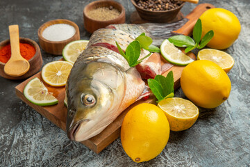 front view sliced fresh fish with lemon and seasonings on light background ocean raw seafood