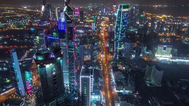 Skyline with Skyscrapers night timelapse in Kuwait City downtown illuminated at dusk. Aerial view from rooftop at foggy weather. Kuwait City, Middle East.