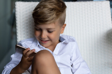 Happy boy talking to someone via video call over smart phone.