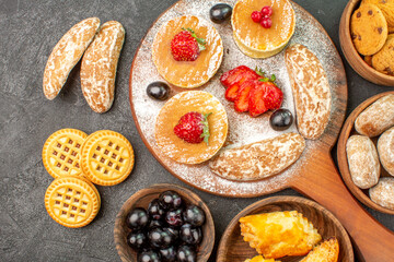 top view tasty pancakes with different sweets on dark background sugar cake dessert