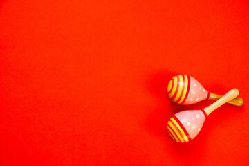 Maracas on a bright red background. On the left is the copy space. Selective focus, shallow depth of field