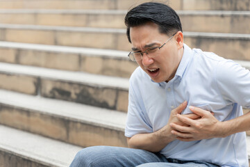 Fototapeta premium asian male suffering from bad pain in his chest heart attack- senior heart disease