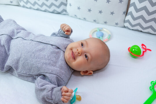 happy newborn in the crib smiles charmingly