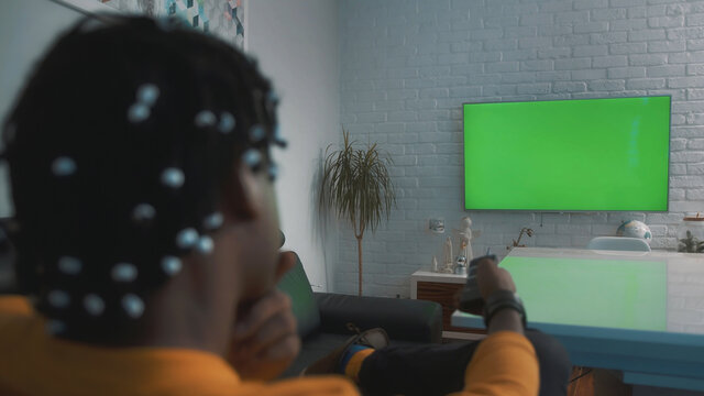 African american black man watching big green tv screen. High quality photo