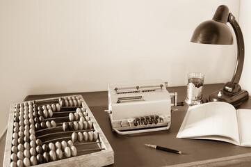 Mechanical calculator, wooden abacus, vintage table lamp on an old table. Accounting and auditing.