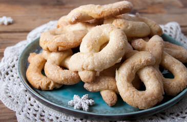 On an old wooden table a plate of berlin wreaths cookies
