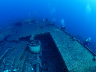 scuba divers exploring shipwreck scenery underwater ship wreck deep blue water ocean scenery of...