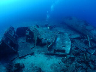 scuba divers exploring shipwreck scenery underwater ship wreck deep blue water ocean scenery of...