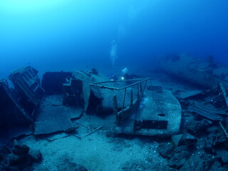 scuba divers exploring shipwreck scenery underwater ship wreck deep blue water ocean scenery of...