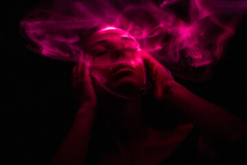 Girl, model photographed on a long exposure in the studio with color filters. Portrait