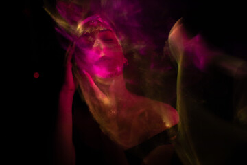 Girl, model photographed on a long exposure in the studio with color filters. Portrait