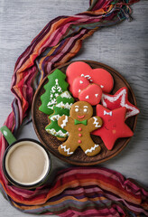 A bowl of gingerbread and a mug of hot chocolate wrapped in a scarf.